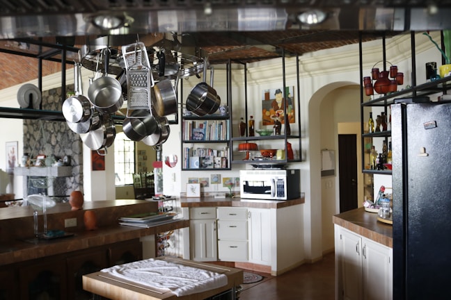 Cookware storage racks arranged above a kitchen island, showcasing organized and easy-to-reach pots.