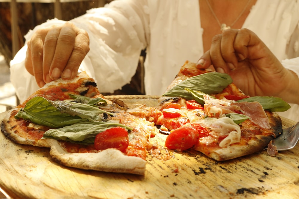 person in white long sleeve shirt holding sliced pizza