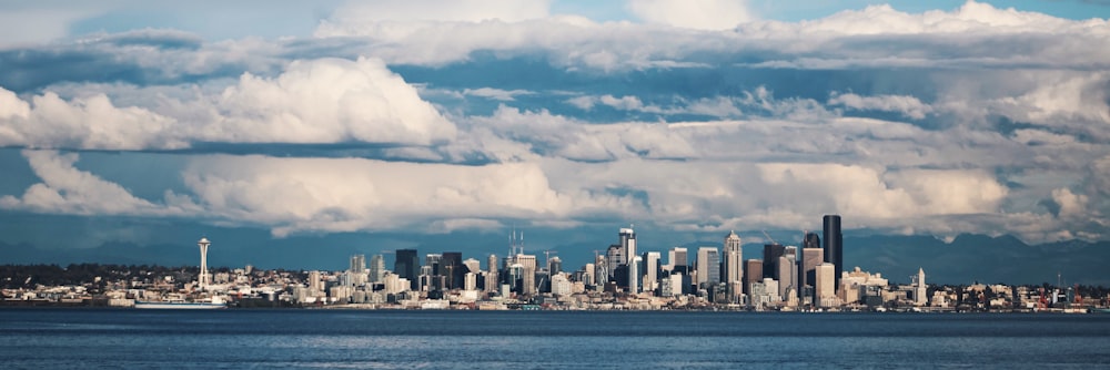 city skyline under white clouds and blue sky during daytime