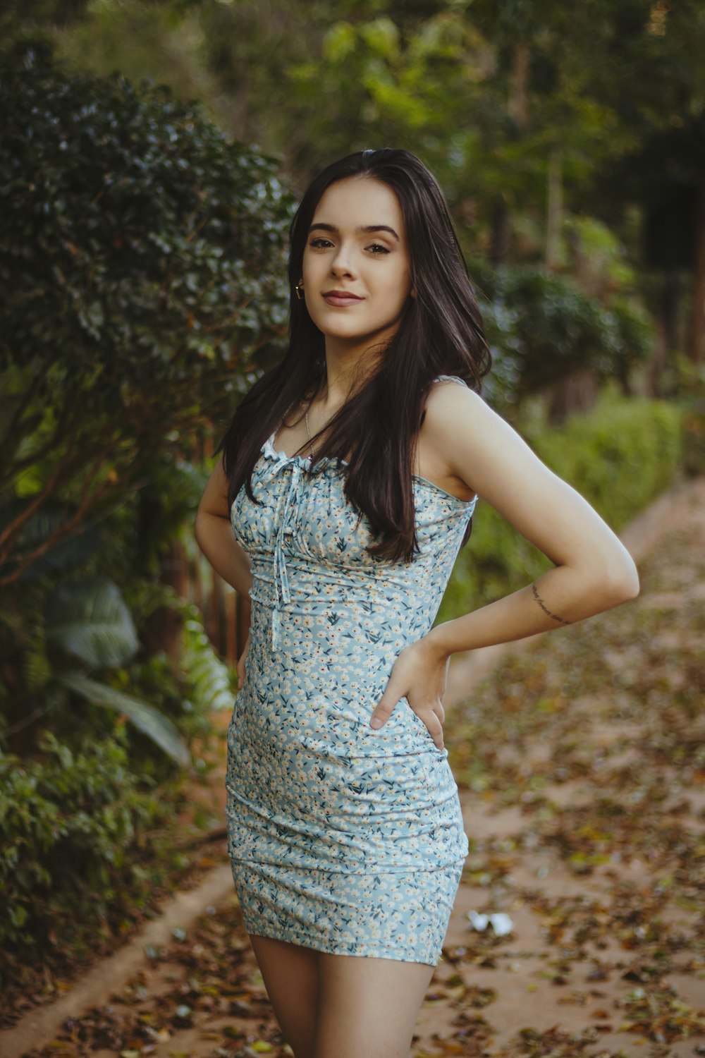 woman in white sleeveless dress standing near green plants during daytime