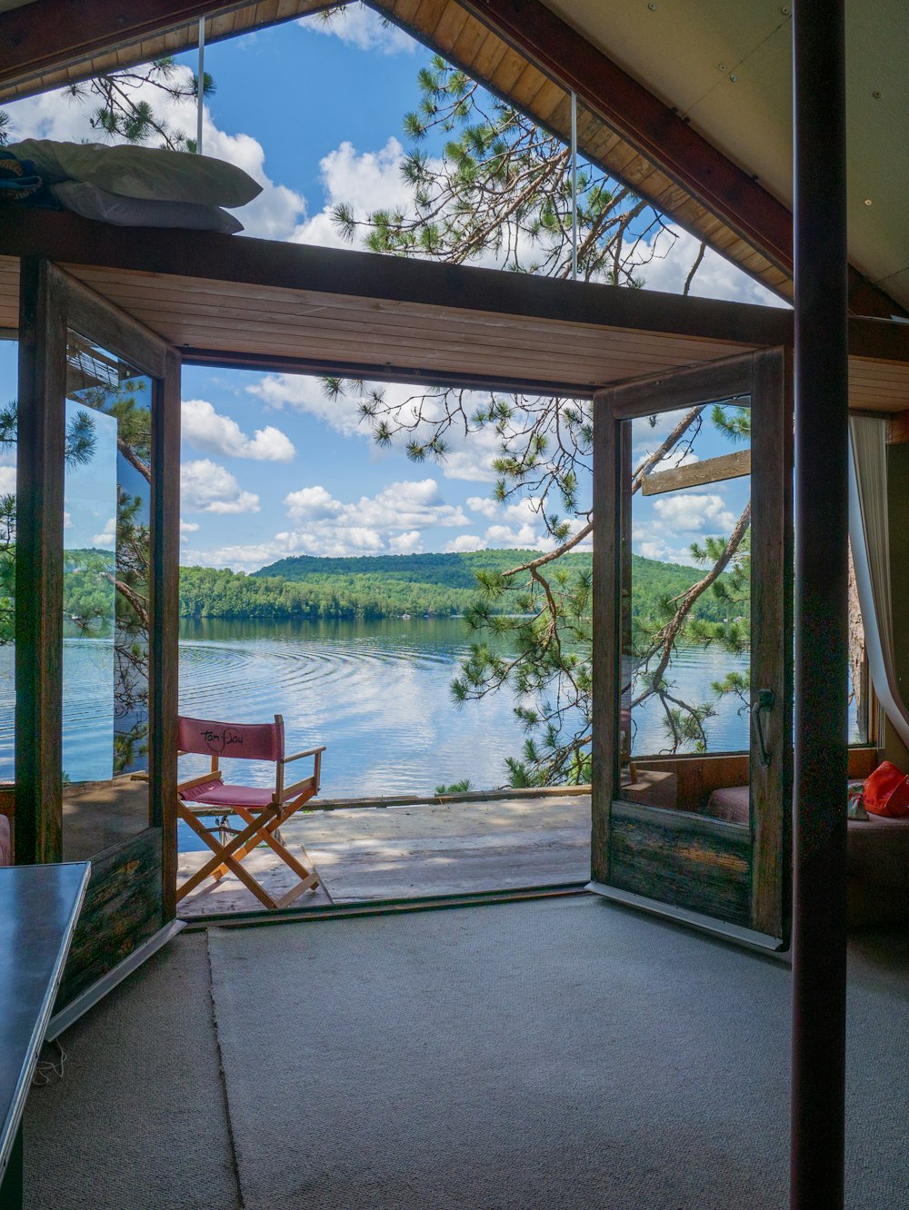 brown wooden framed glass window near green body of water during daytime