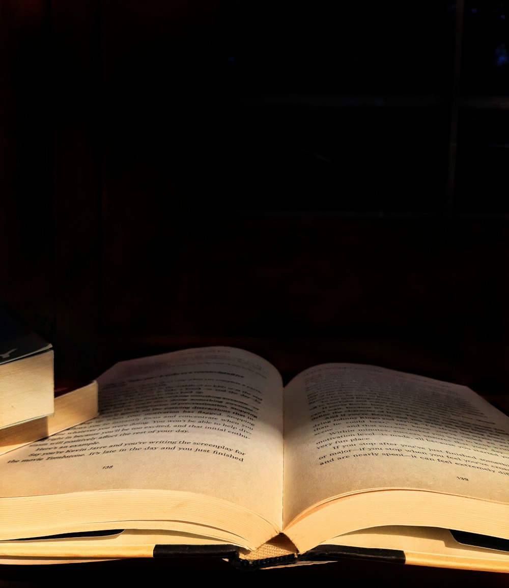 opened book on brown wooden table