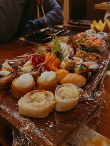 A beautifully arranged platter of assorted sushi rolls on a wooden table.