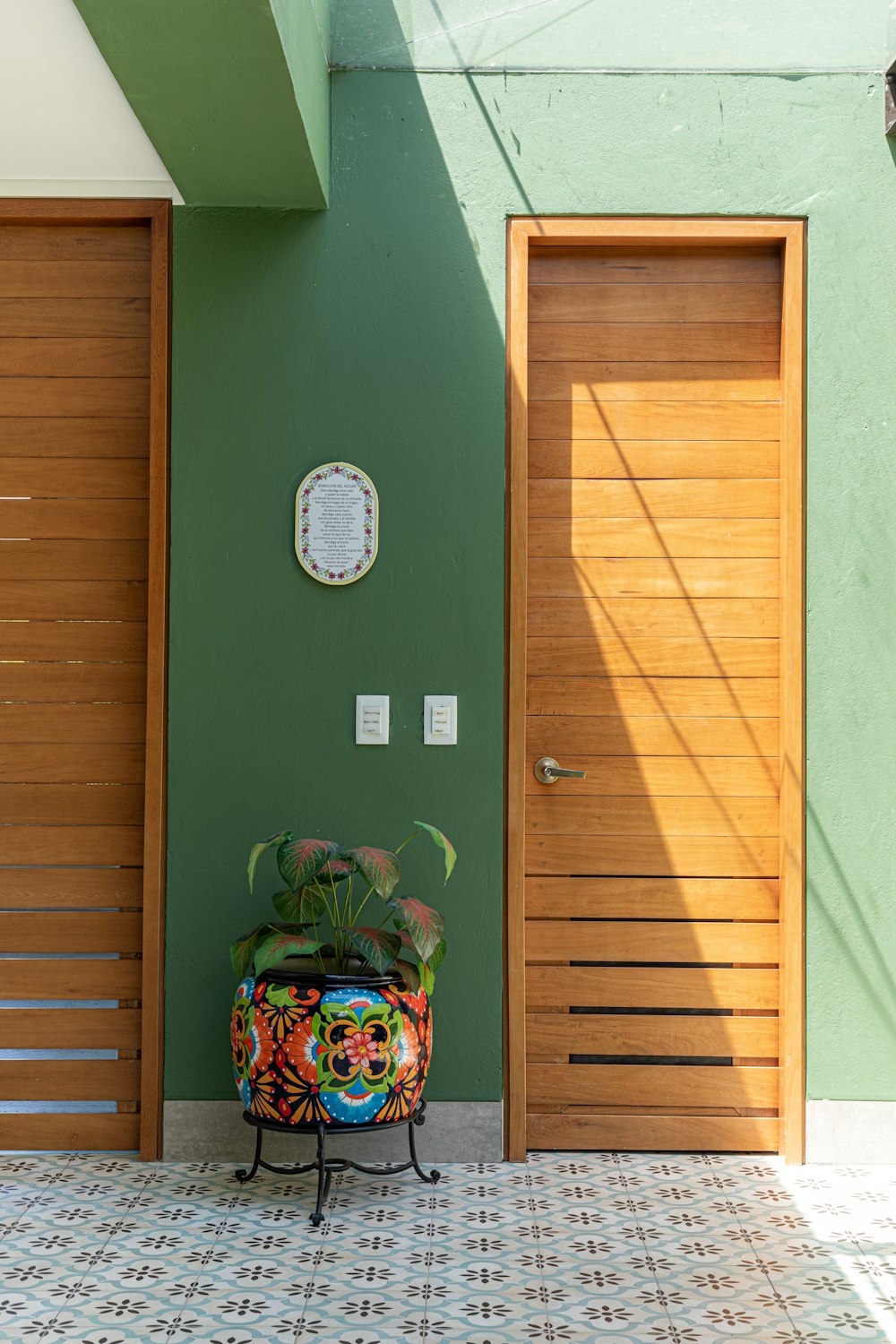 green wooden door with green and white floral wreath