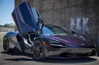 purple lamborghini aventador parked near gray concrete wall