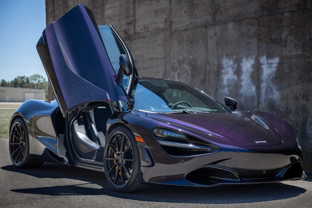 purple lamborghini aventador parked near gray concrete wall