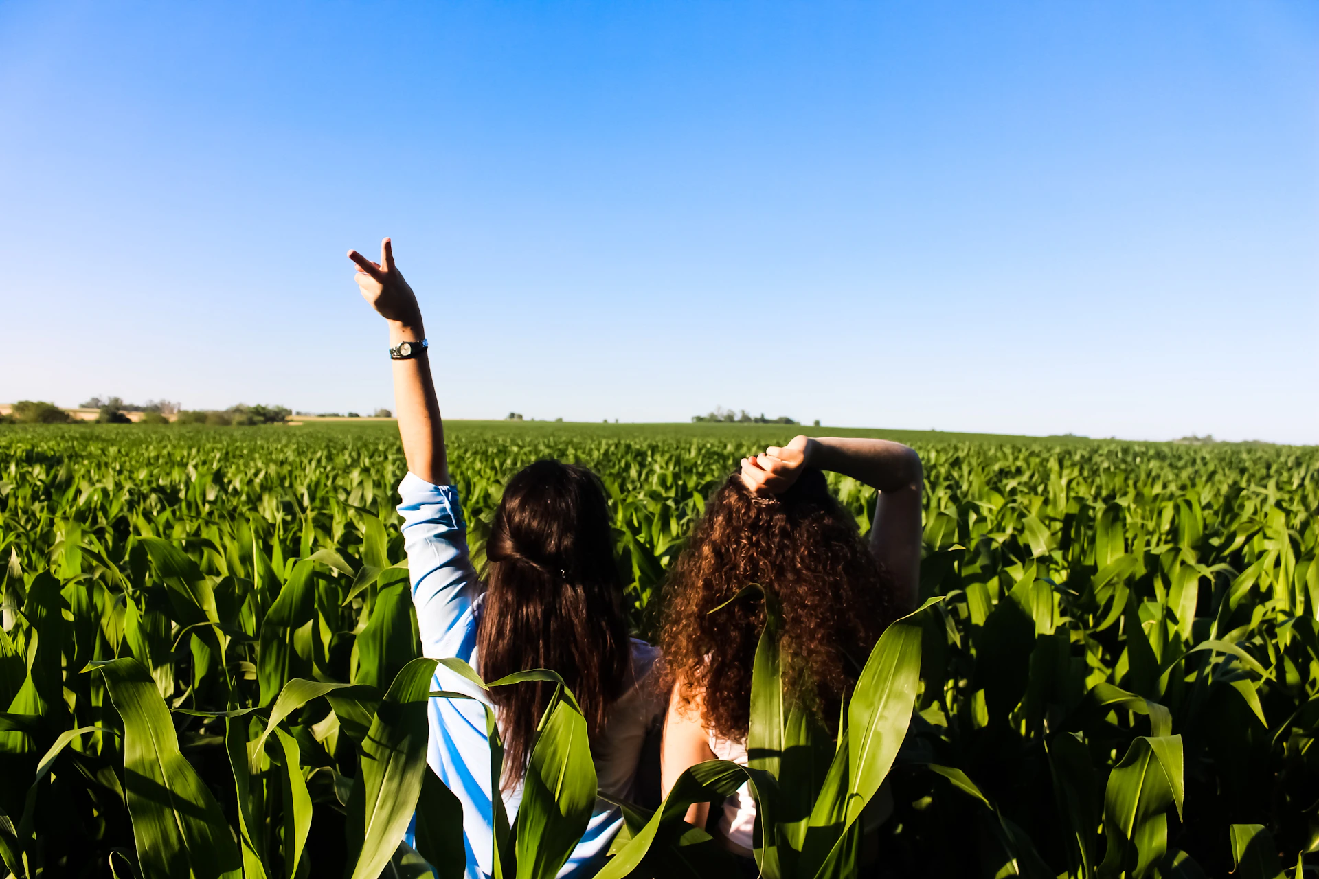 woman in black and white stripe shirt standing on green grass field during daytime