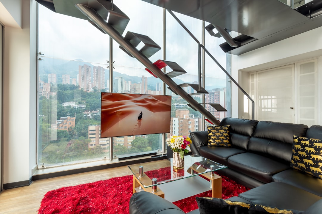 black leather couch beside glass table