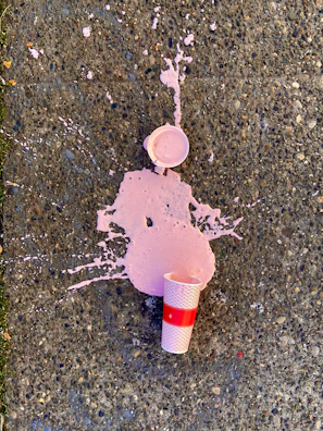 A filling nozzle dripping uncontrollably onto a grimy floor stained with beverage spills.