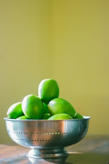 green and yellow apples in white ceramic bowl