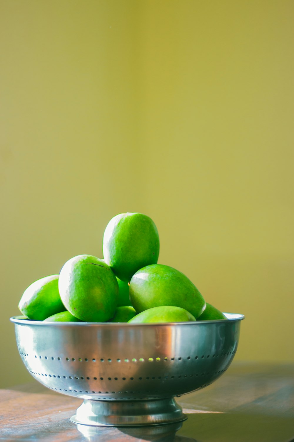 green and yellow apples in white ceramic bowl