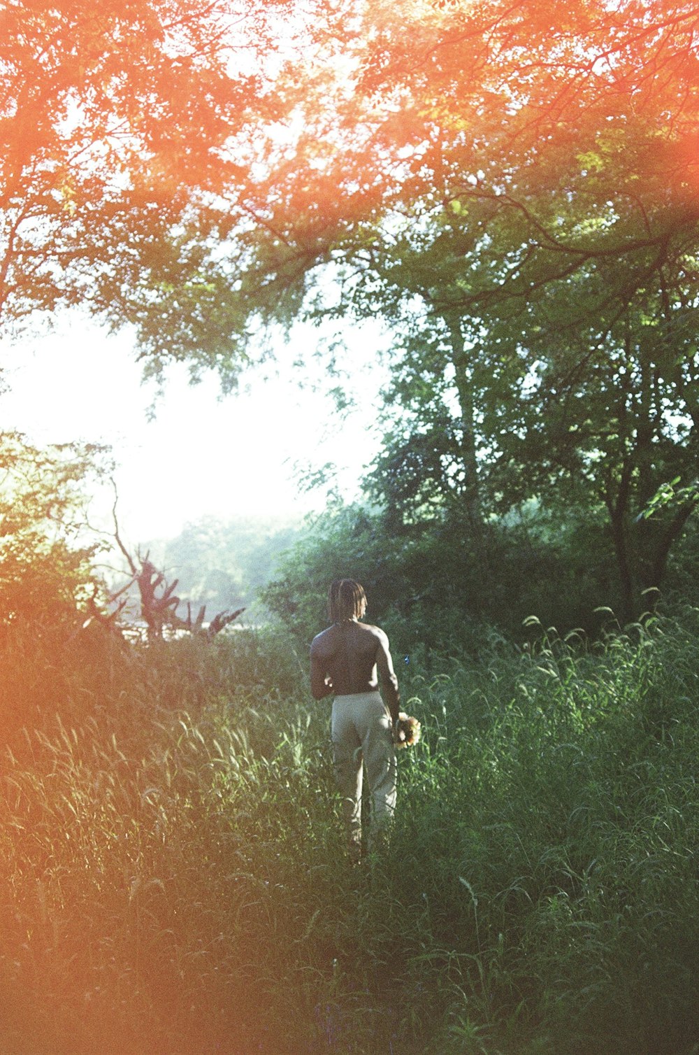 woman in black shirt and white pants standing on green grass field during daytime