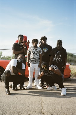 A diverse group of people wearing modern streetwear outfits outdoors.