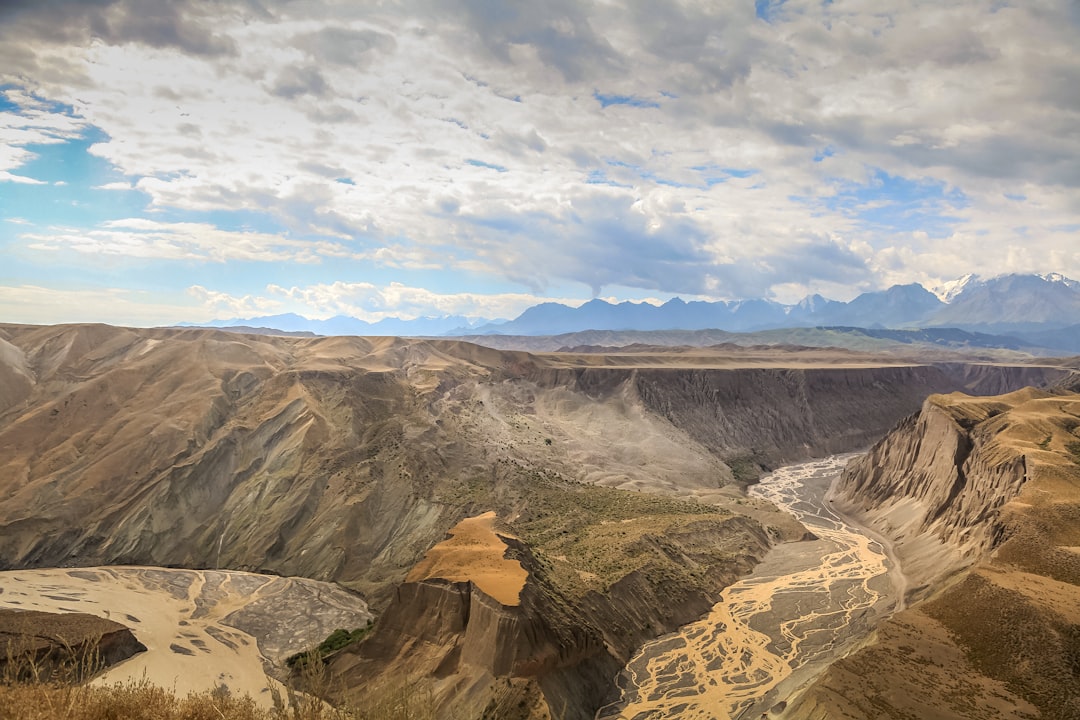 brown and gray mountains under white clouds and blue sky during daytime