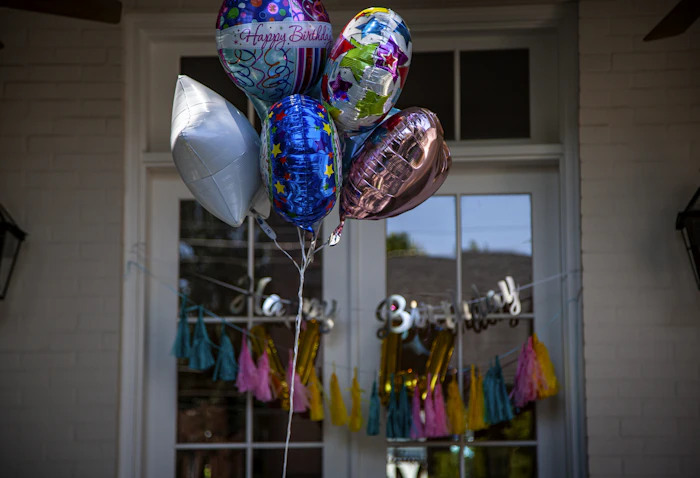 Assorted colourful balloons strung across a party backdrop