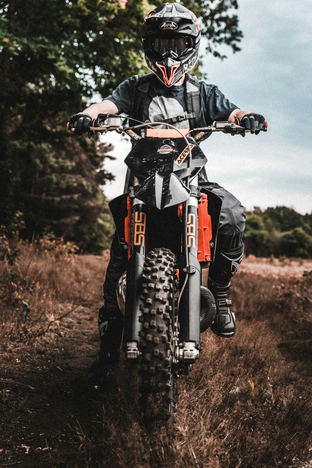 man in black jacket riding red and black motocross dirt bike