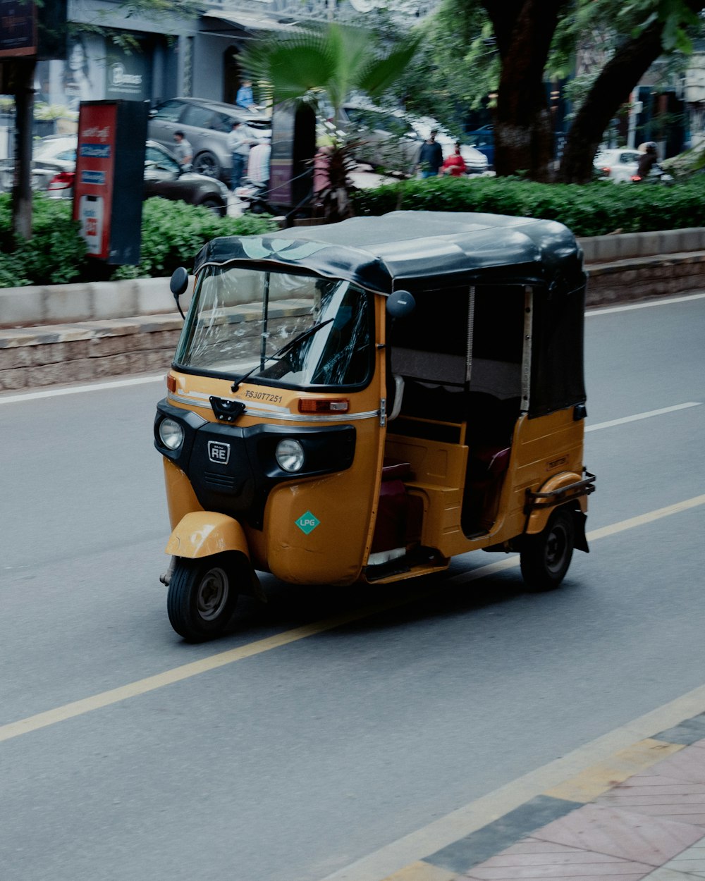 yellow and black auto rickshaw on road during daytime