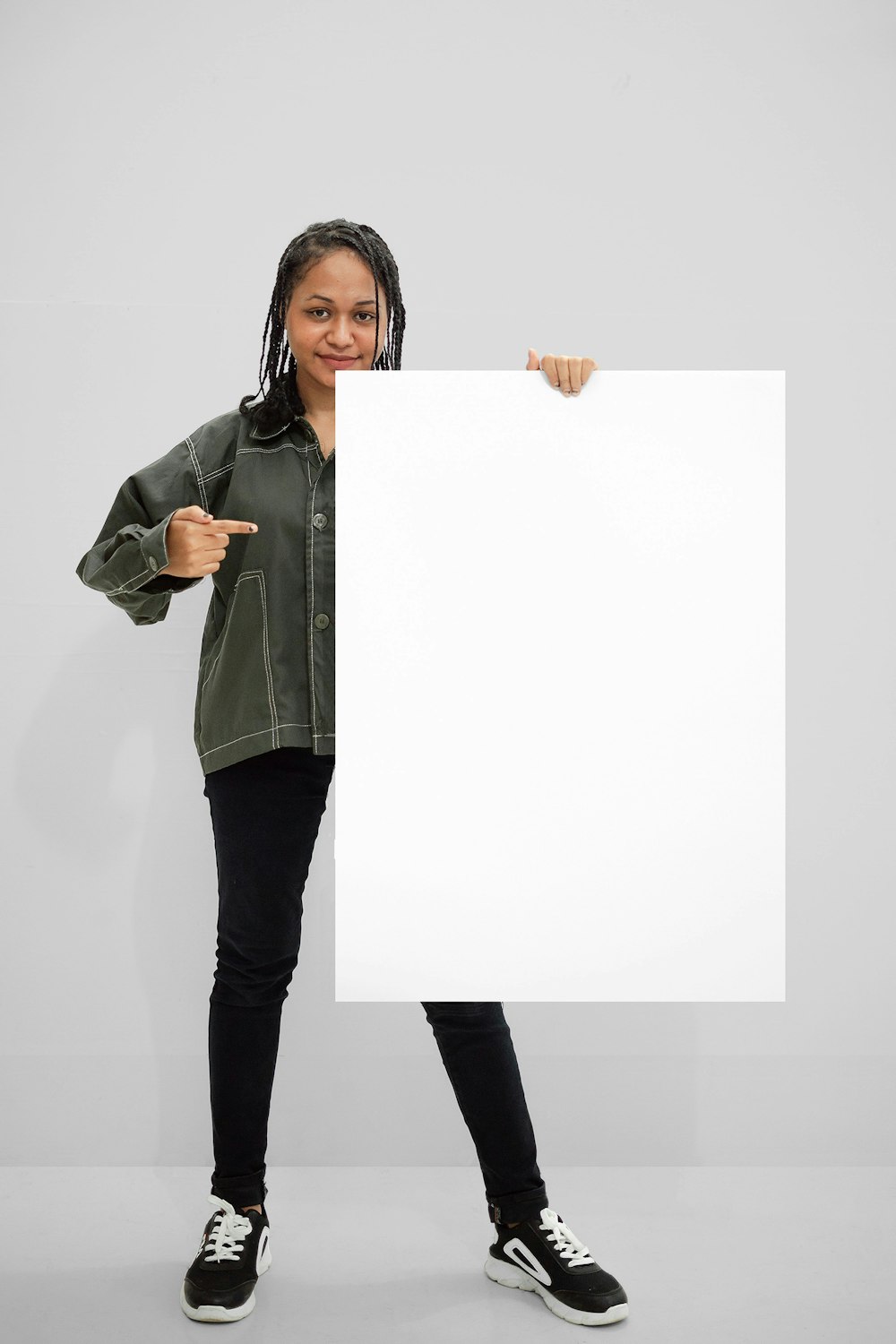woman in green jacket holding white paper
