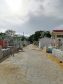 white and red concrete building near green trees under white clouds during daytime
