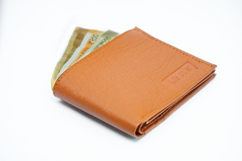 brown leather bifold wallet on white surface