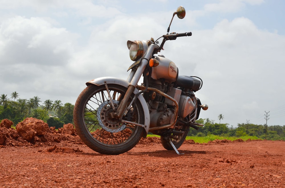 Motocicleta negra y gris en camino de tierra marrón durante el día