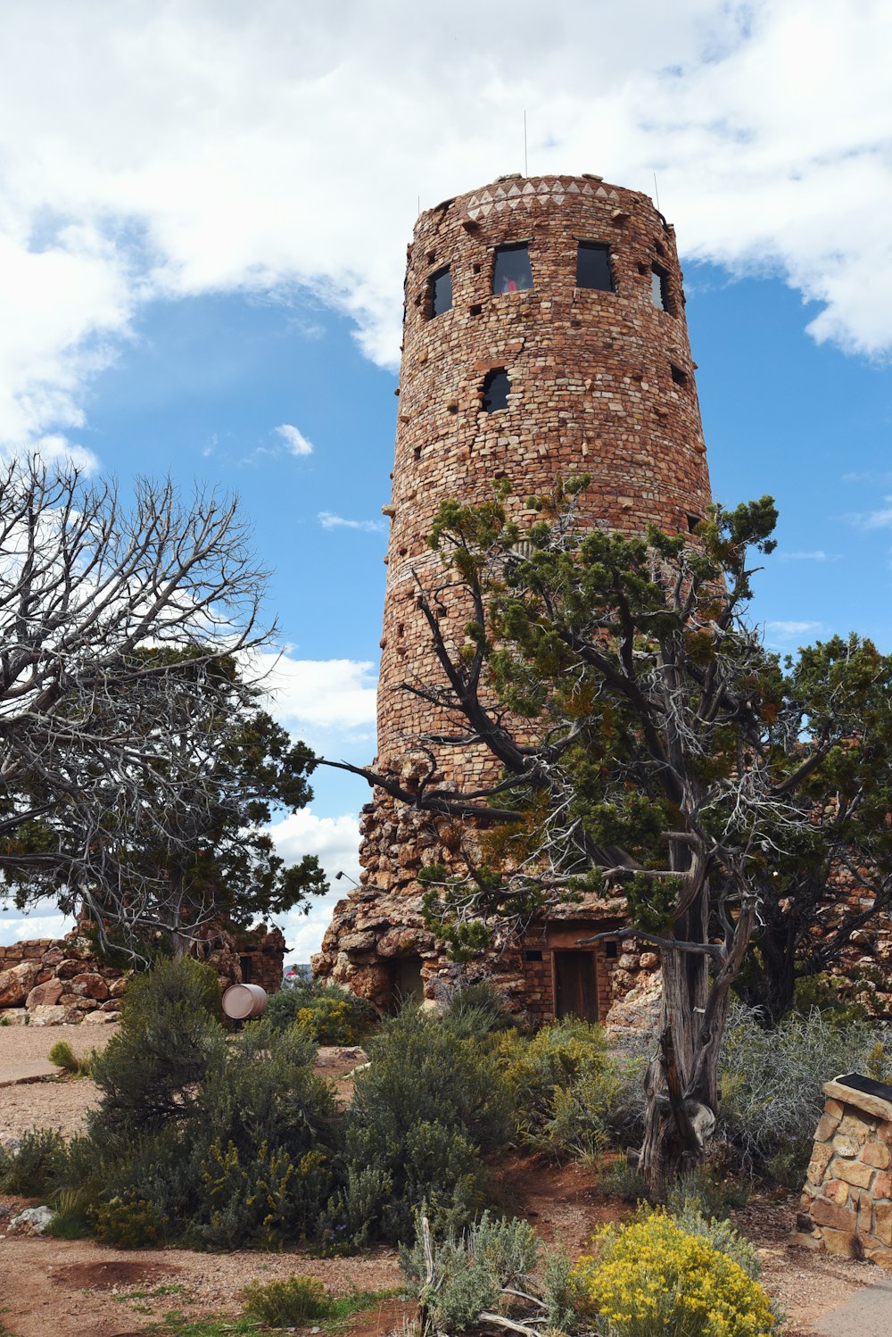 brown concrete tower near bare trees under blue sky during daytime