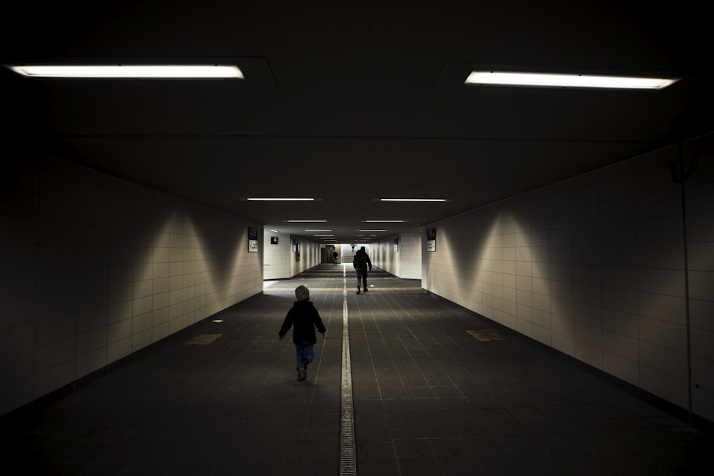 woman in blue jacket walking on hallway