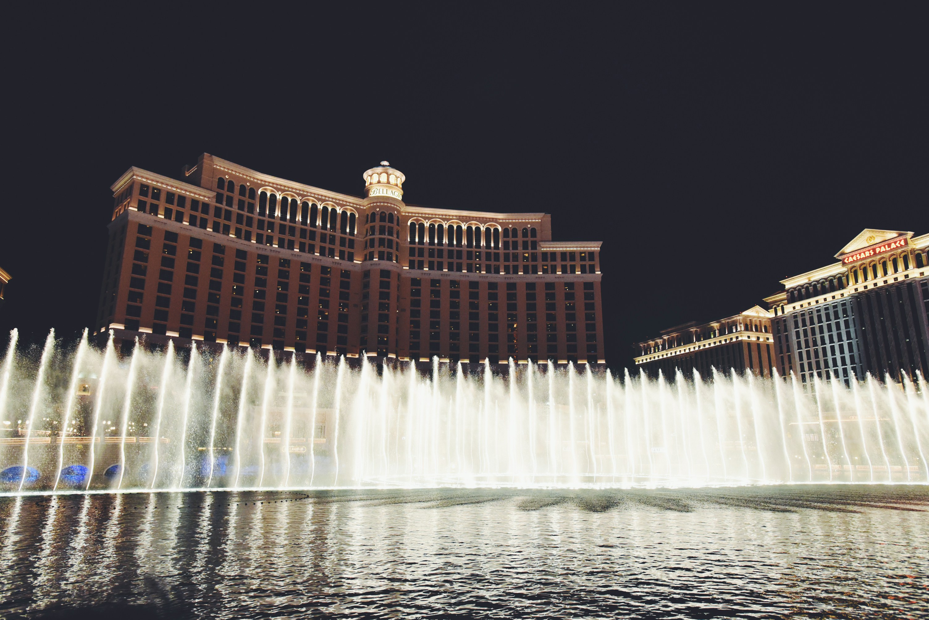 water fountain in front of brown building during nighttime, 音乐喷泉
