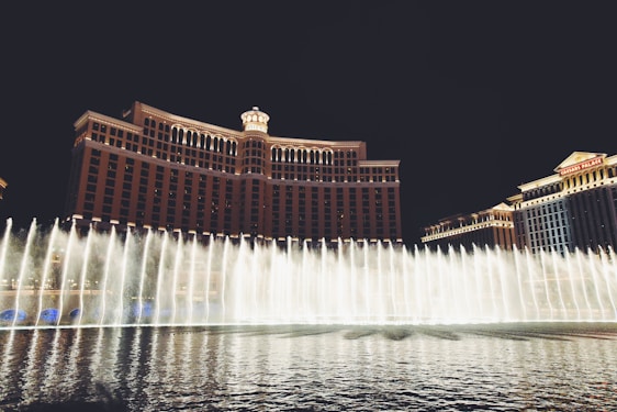 water fountain in front of brown building during nighttime