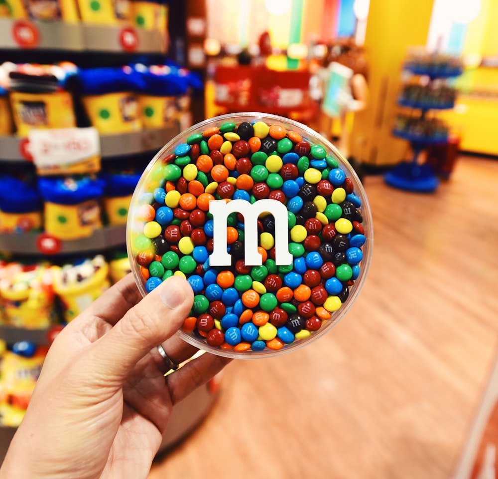 person holding m ms chocolate candies