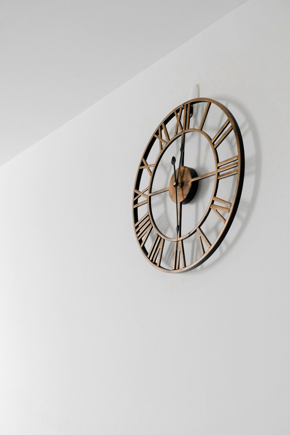 gold round wall clock on white painted wall