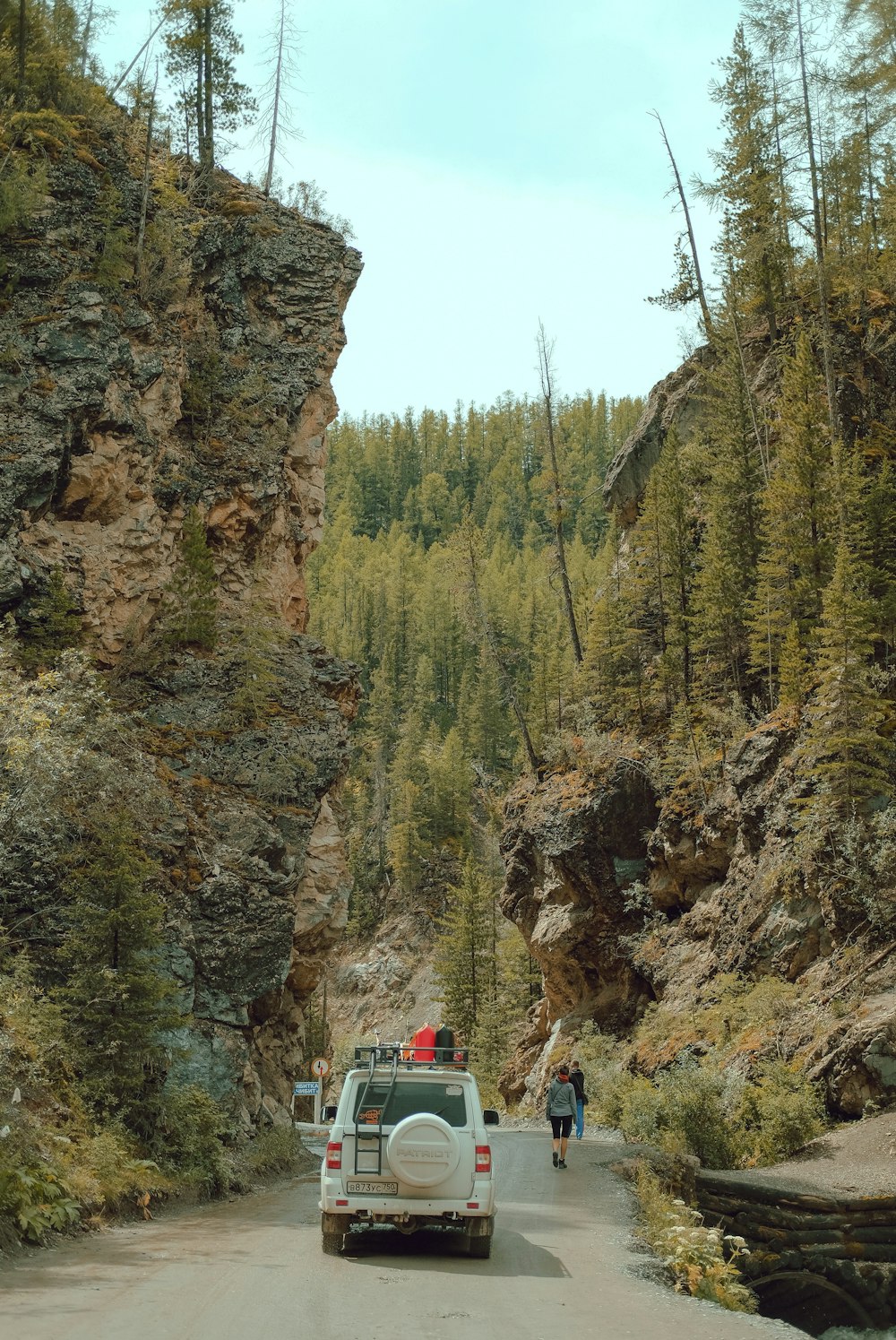 people walking on road between rocky mountain during daytime