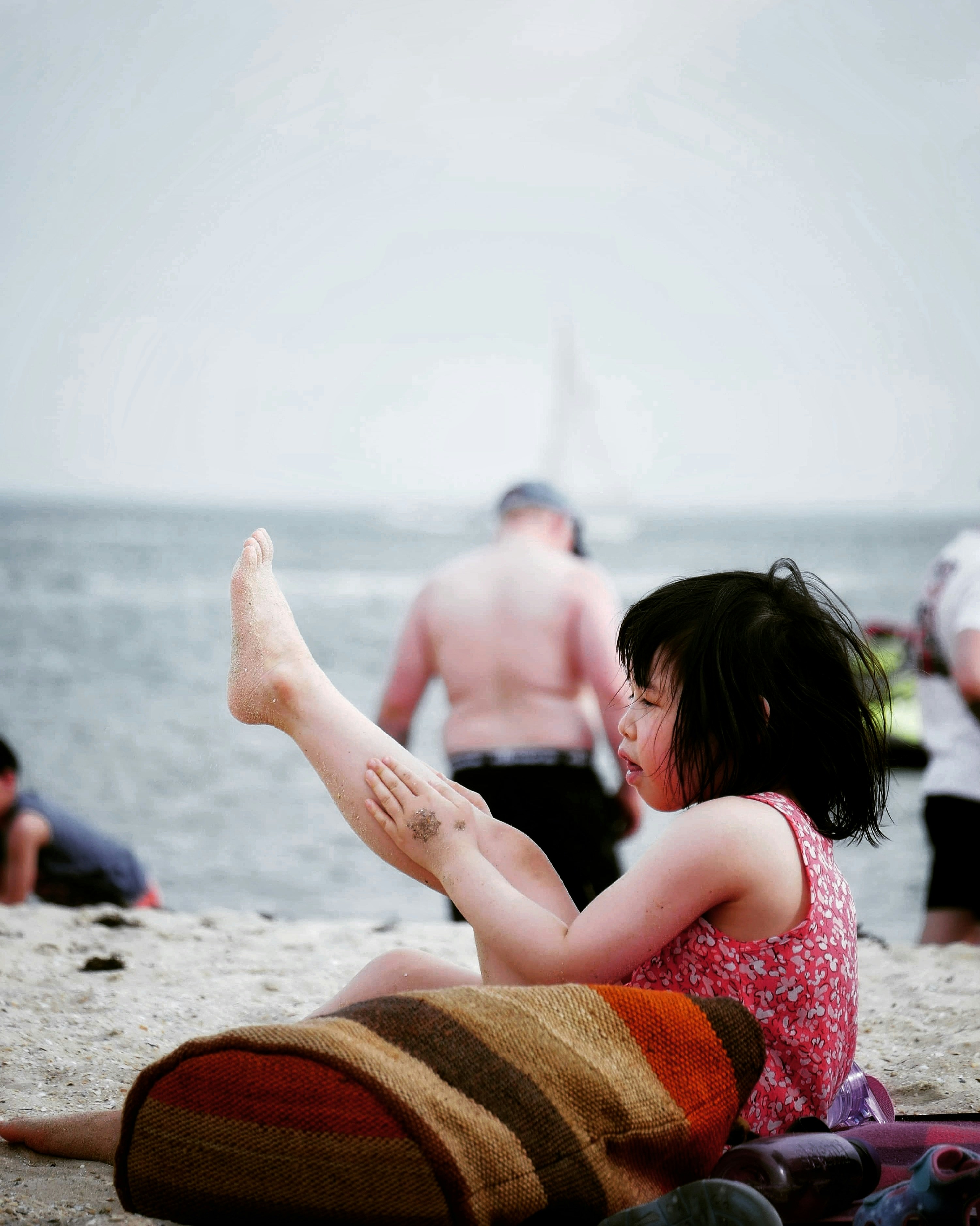 2 women sitting on beach shore during daytime