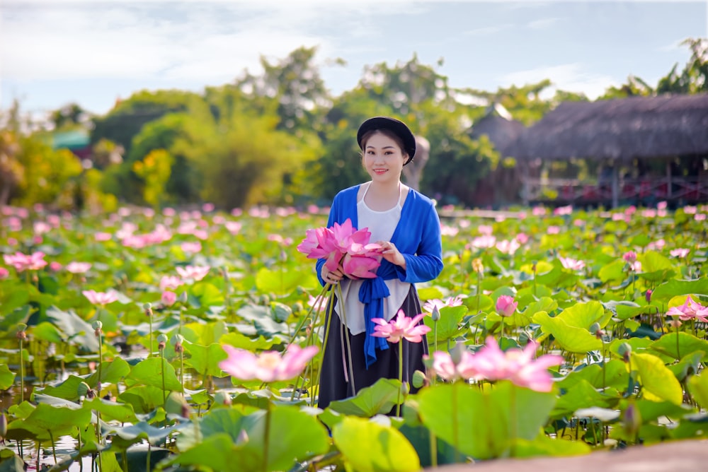 girl in blue and pink dress holding pink flower