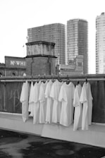 white textile hanged on black metal fence