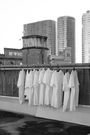 white textile hanged on black metal fence