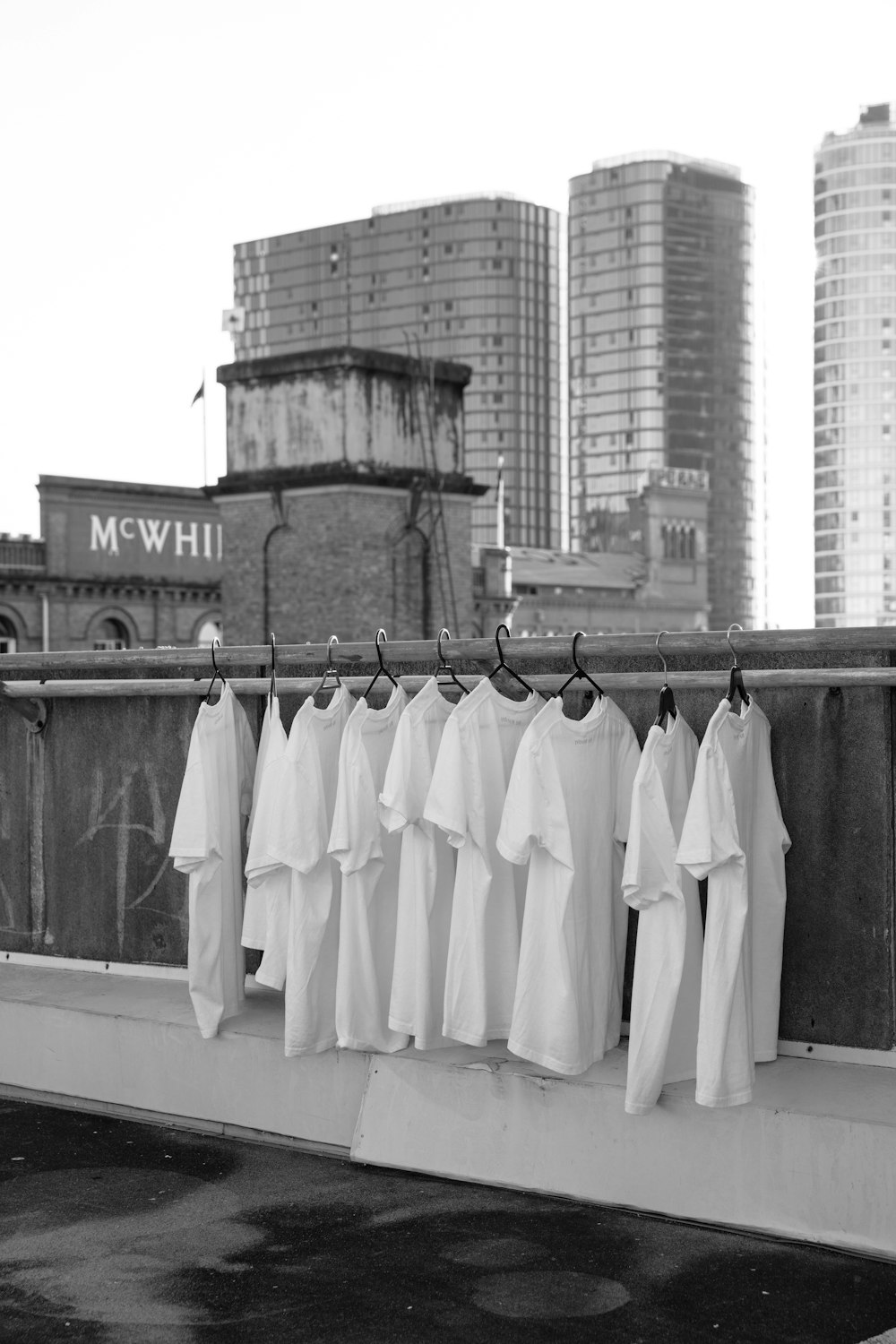 white textile hanged on black metal fence