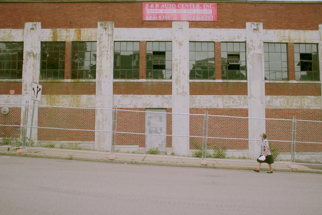 man in black jacket walking on sidewalk during daytime