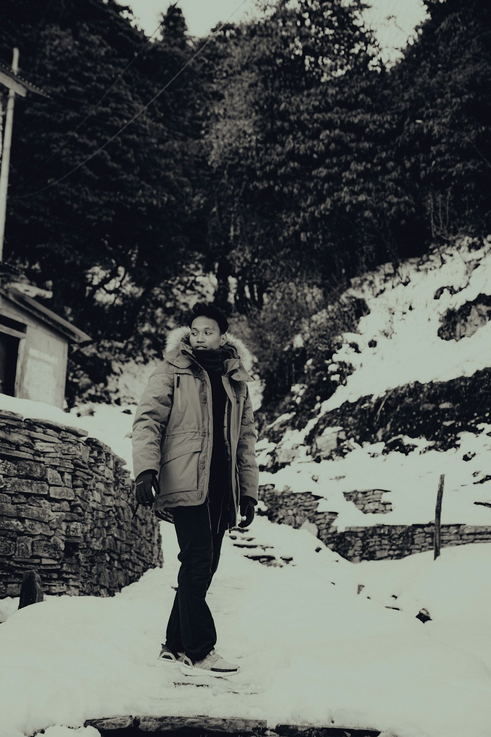 woman in brown coat standing on snow covered ground