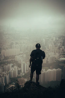 man in black jacket and black pants standing on top of building during daytime