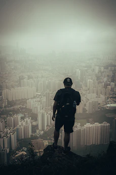 man in black jacket and black pants standing on top of building during daytime