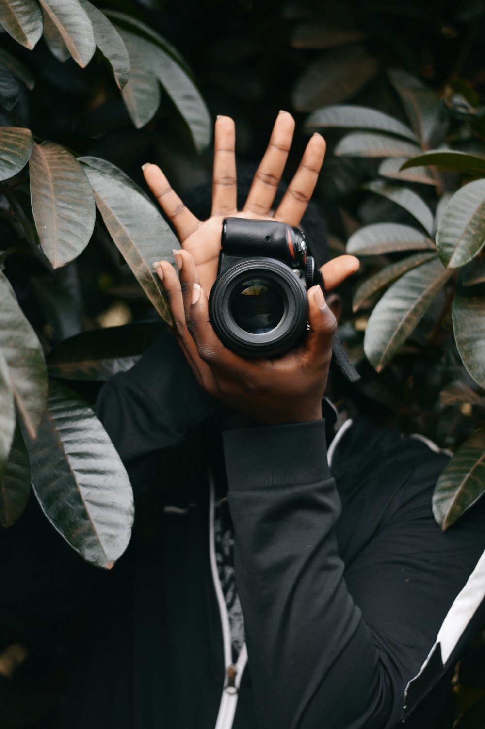 man in black jacket holding black camera