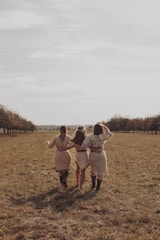 man and woman walking on green grass field during daytime
