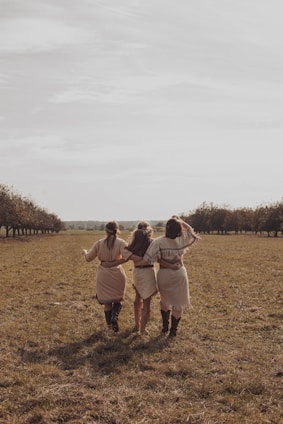 man and woman walking on green grass field during daytime