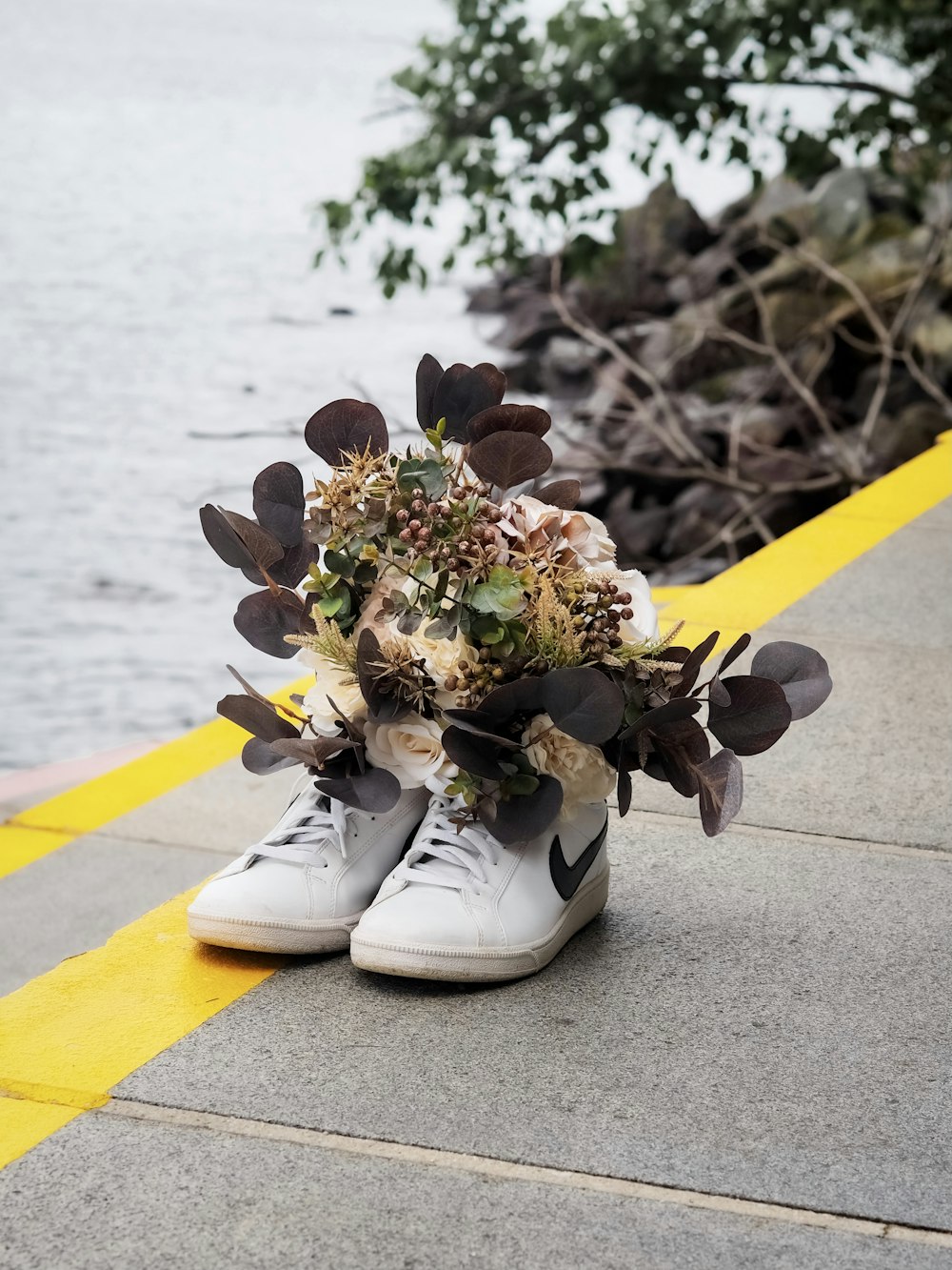 white and yellow sneakers beside white and brown flower bouquet