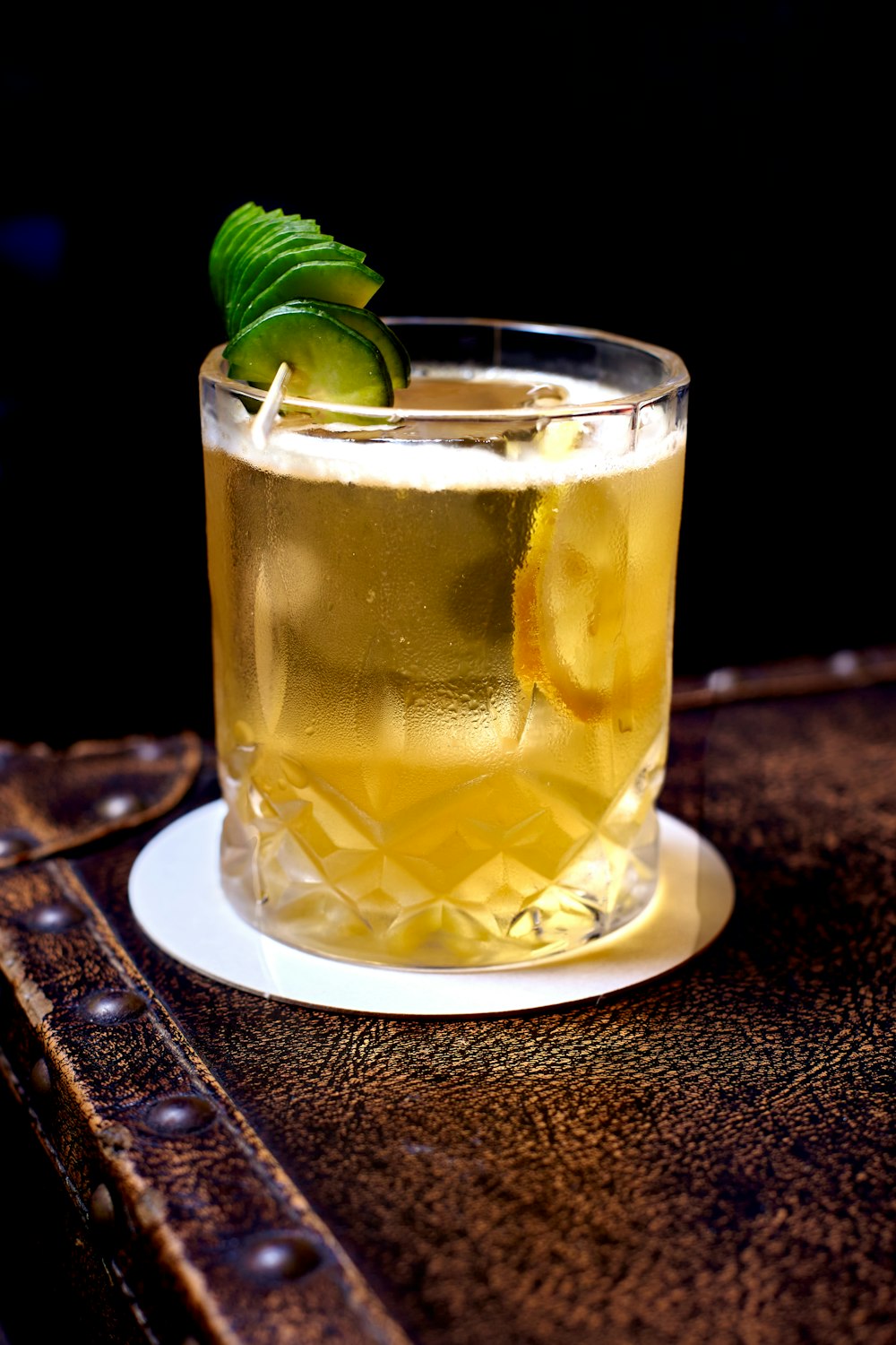 clear drinking glass with yellow liquid and sliced lemon on white ceramic plate