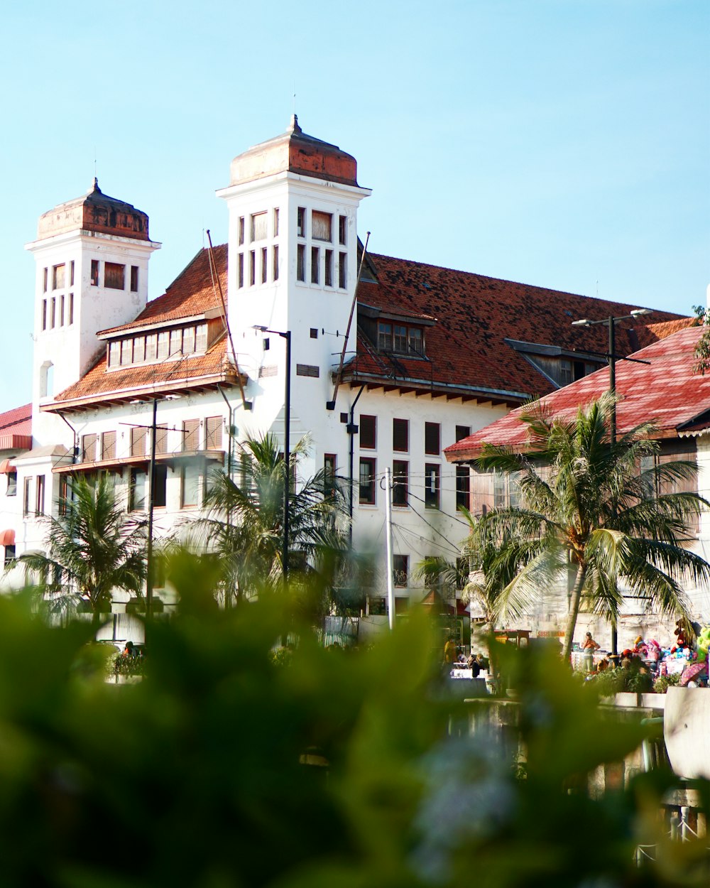 white and brown concrete building near green trees during daytime