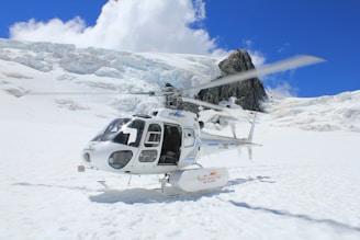 white and black helicopter on snow covered ground during daytime