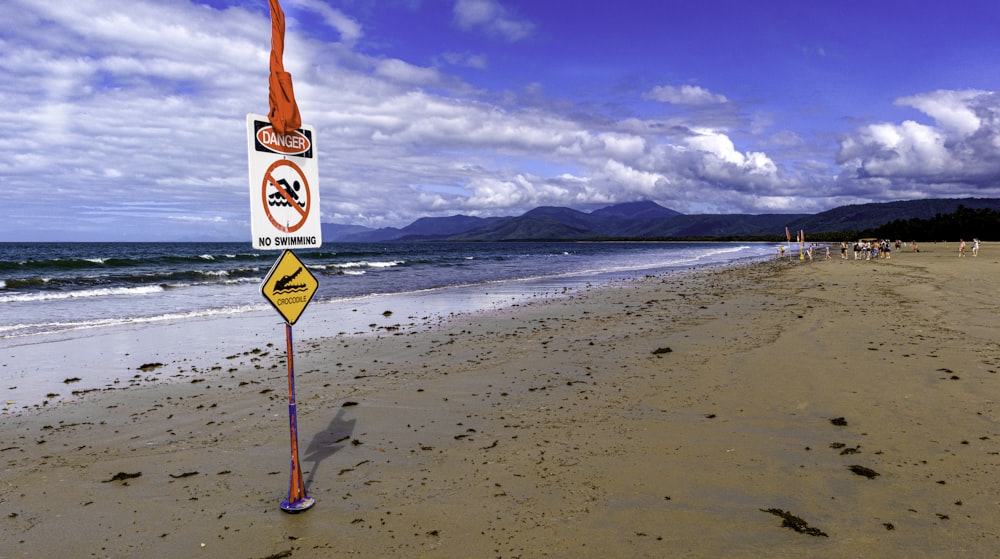 Panneau d’arrêt rouge et blanc sur la plage pendant la journée