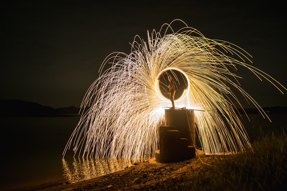 time lapse photography of person standing on beach during night time